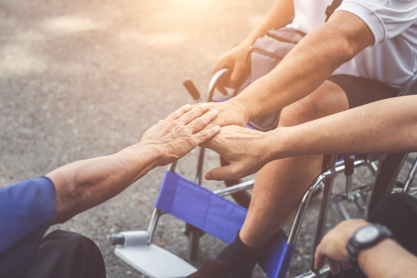 A caregiver holding the hand of a person they care for