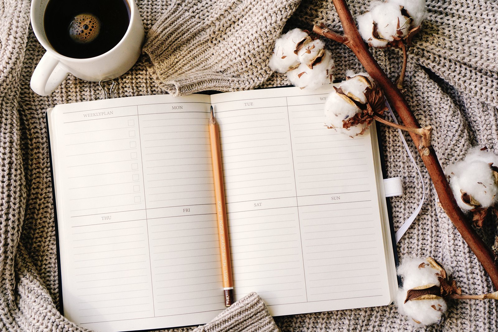 An open planner and notebook on a warm knit throw — tracking supervised hours from day one
